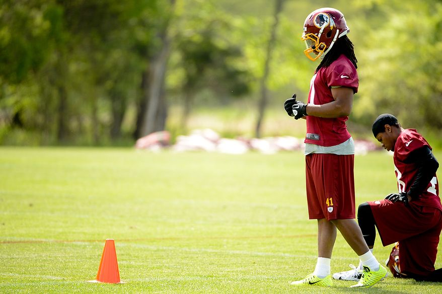 Newly drafted Washington Redskinis safety Phillip Thomas (second from right) watches scrimmage drills from the sidelines at the team's rookie minicamp at Redskins Park in Ashburn, Va., on Sunday, May 5, 2013. (Andrew Harnik/The Washington Times)