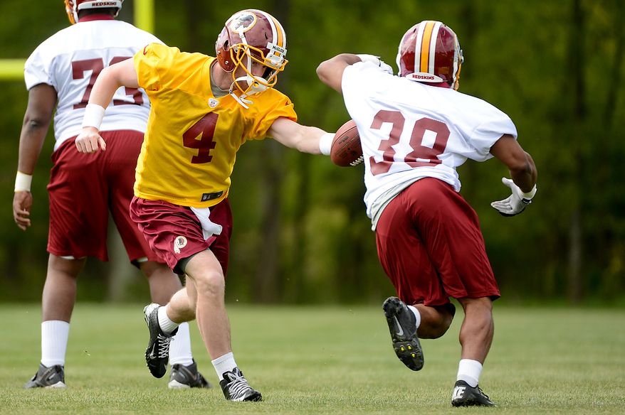 Quarterback Matthew McGloin (4) hands off to running back Shawn Morris (38) at the Washington Redskins' rookie minicamp at Redskins Park in Ashburn, Va., on Sunday, May 5, 2013. (Andrew Harnik/The Washington Times)