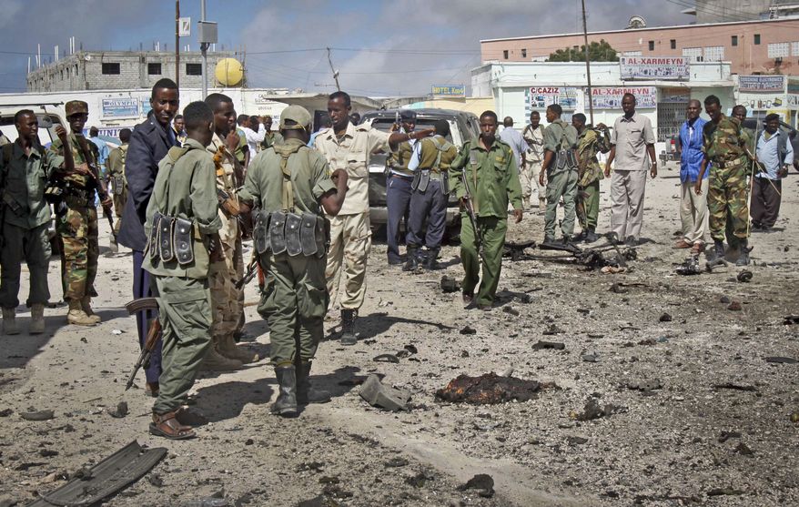 Soldiers gather at the scene of a suicide car bomb blast in Mogadishu, Somalia, on Sunday, May 5, 2013. (AP Photo/Farah Abdi Warsameh)