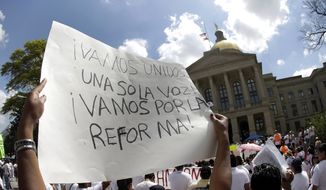 A protester for immigration reform holds a sign during a rally at the Georgia Capitol in Atlanta on April 10, 2013. (Associated Press) **FILE** 