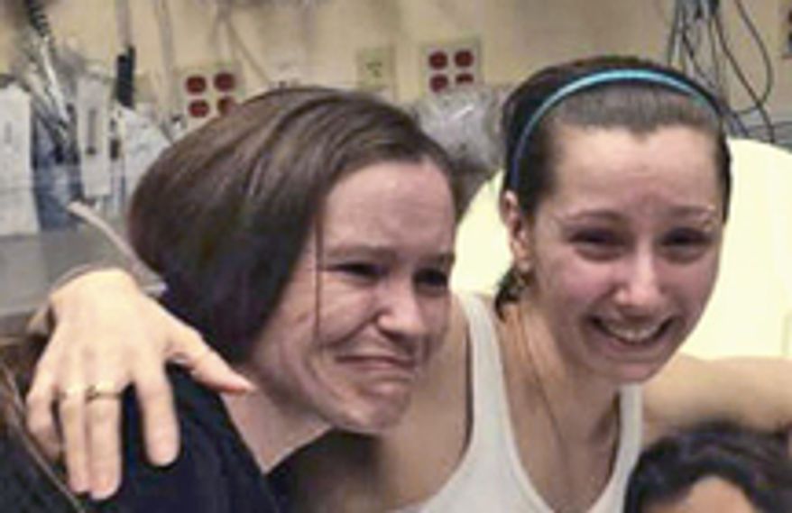 Amanda Berry (right) is reunited with her sister Beth Serrano in a Cleveland hospital Monday after she was reported missing a decade ago. (Berry Family handout via Associated Press)