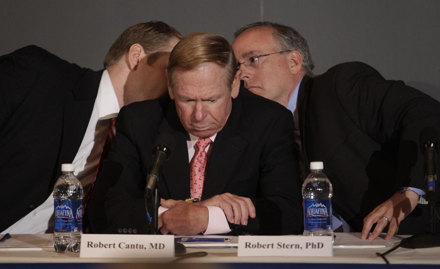 **FILE** Dr. Robert Stern, right, and Chris Nowinski, left, confer before answering a reporter's question at the Boston University Center for the Study of Traumatic Encephalopathy news conference about the finding of Chronic Traumatic Encephalopathy in the brain of former NFL player Dave Duerson in Boston, Monday morning, May 2, 2011. Duerson committed suicide in February. Dr. Robert Cantu, MD, is at center. (AP Photo/Stephan Savoia)