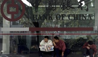 ** FILE ** In this photo taken Tuesday, Jan 6, 2004, Chinese men share a newspaper outside a Bank of China branch in Guangzhou, southeastern China Guangdong province. One of China&#39;s biggest banks said Tuesday, May 7, 2013, that it has halted business with the Foreign Trade Bank of North Korea. (AP Photo/Ng Han Guan)