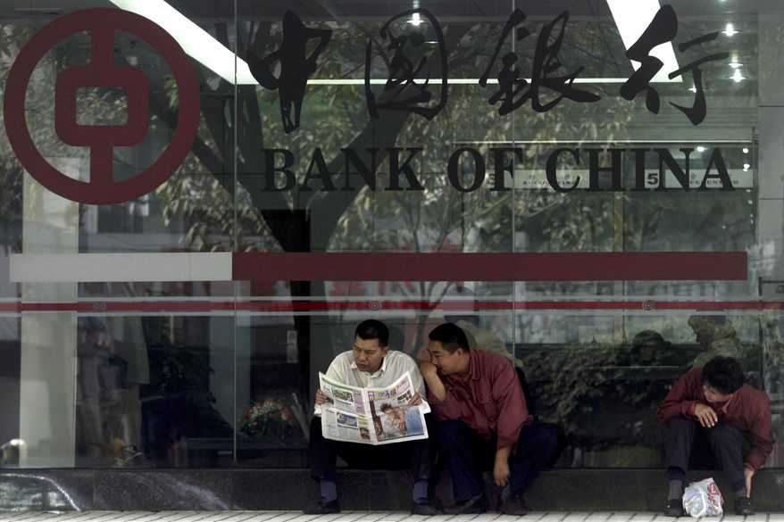 ** FILE ** In this photo taken Tuesday, Jan 6, 2004, Chinese men share a newspaper outside a Bank of China branch in Guangzhou, southeastern China Guangdong province. One of China's biggest banks said Tuesday, May 7, 2013, that it has halted business with the Foreign Trade Bank of North Korea. (AP Photo/Ng Han Guan)