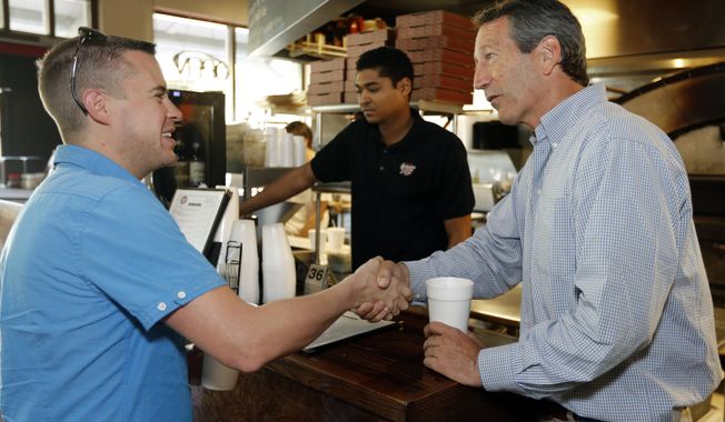 Former South Carolina Gov. Mark Sanford, right, speaks with voter Travis Holt, a mechanic with the U.S. Air Force, at Orlando&#x27;s Pizza in Daniel Island, S.C., on Monday, May 6, 2013. Server Kevin Caughman works at rear. Sanford is making his last campaign push against his Democratic opponent, Elizabeth Colbert Busch, before Tuesday&#x27;s special election. (AP Photo/Mic Smith)