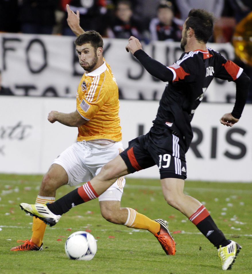 **FILE** Houston Dynamo's Will Bruin, left, kicks the ball as D.C. United's Emiliano Dudar (19) defends during the second half of the second game of an MLS soccer Eastern Conference final playoff series, Sunday, Nov. 18, 2012, in Washington. The Dynamo advanced to their second straight MLS Cup final and fourth in seven years, tying D.C. United 1-1 Sunday for a 4-2 aggregate win in the Eastern Conference final. (AP Photo/Luis M. Alvarez)