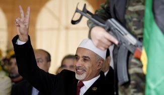 **FILE** Mohamed al-Megariaf, then the Libyan interim president, flashes the victory sign to crowds during the celebration of the second anniversary of the Libyan revolution in Benghazi, Libya, on Sunday, Feb. 17, 2013. (Associated Press)