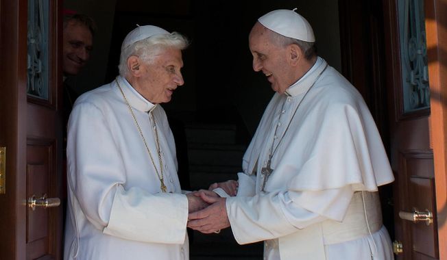 Pope Emeritus Benedict XVI (left) is welcomed by Pope Francis as he returns to the Vatican from the pontifical summer residence of Castel Gandolfo, southeast of Rome, on Thursday, May 2, 2013. (AP Photo/Osservatore Romano)

