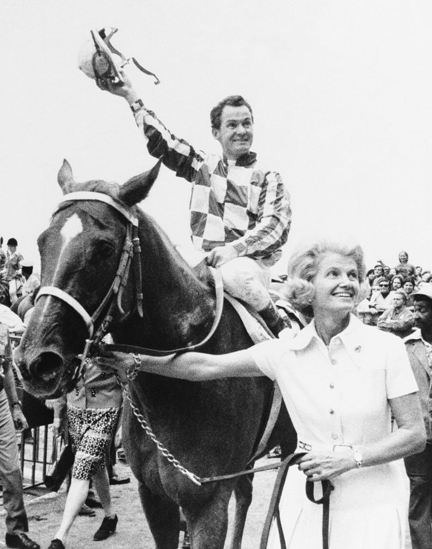 Penny Chenery leads Secretariat to the Winner's Circle at Belmont racetrack in Elmont, New York , Sept. 15, 1973, after he won the $250,000 Marlboro Cup Race. Jockey Ron Turcotte tips his hat to the race fans. (AP Photo)