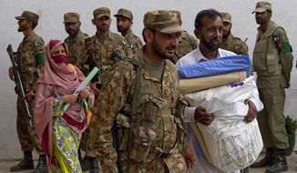 A Pakistani army soldier escorts election staff carrying ballots for the next day&#39;s elections in Islamabad, Pakistan, on May 10, 2013. (Associated Press)