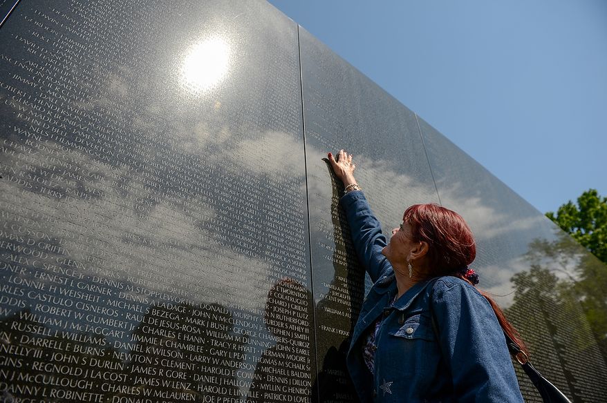 Patty Thompson of West Palm Beach, Fla., reaches up to touch the name of her husband, Spc. Raymond Clark Thompson who has been added to the wall of the Vietnam Veterans Memorial following a Mother's Day ceremony to honor Raymond and three other American servicemen who have been added to the wall, Washington, D.C., Sunday, May 12, 2013. (Andrew Harnik/The Washington Times)