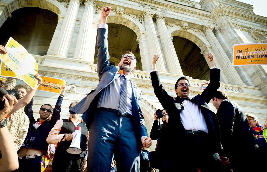 State Sen. D. Scott Dibble (left), sponsor of the gay marriage bill in the Minnesota Senate, and his partner Richard Leyva greet a crowd at the State Capitol. Gov. Mark Dayton said he will sign the bill as early as Tuesday. (Associated Press)