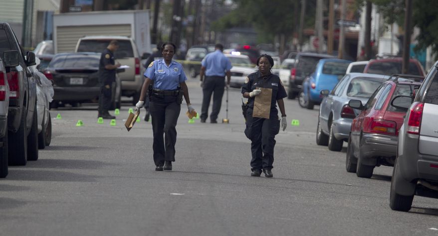 New Orleans Police investigate shooting at the intersection Frenchman Street at N. Villere on Mother's Day in New Orleans, Sunday May 12, 2013. Gunmen opened fire on dozens of people marching in a Mother's Day neighborhood parade in New Orleans on Sunday, wounding at least 17, police said. (AP Photo/Doug Parker)