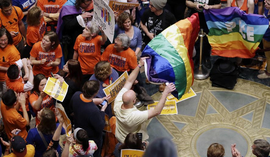 Thousands filled the Minnesota State Capitol as they waited for word that the Senate had passed the gay marriage bill Monday, May 13, 2013, in St. Paul, Minn. The governor has now signed the bill into law. (AP Photo/Jim Mone) **FILE**