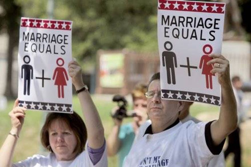 ** FILE ** From left, Martha and Stan Harper hold signs in support of the National Organization for Marriage on Aug. 10, 2010 in Raleigh, North Carolina. (Associated Press)