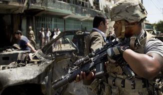 A U.S. soldier arrives to the scene where a suicide car bomber attacked a NATO convoy in Kabul, Afghanistan, Thursday, May 16, 2013. (AP Photo/Anja Niedringhaus)


