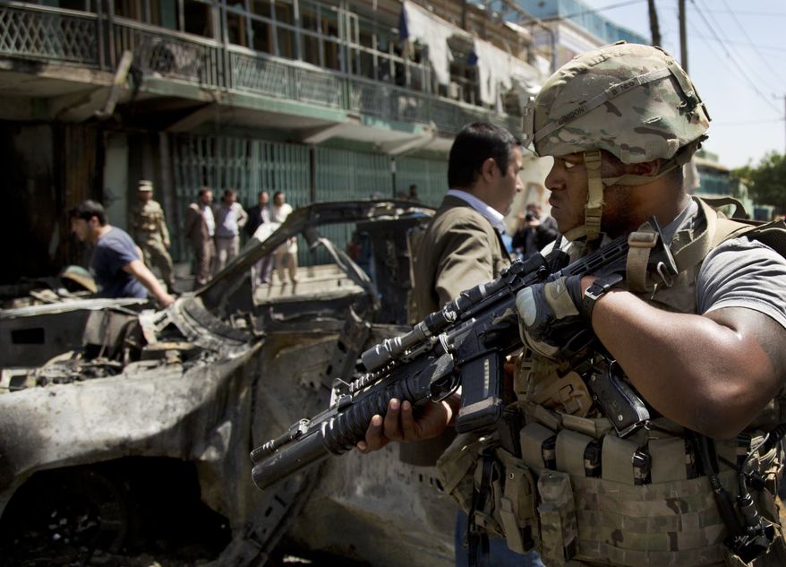 A U.S. soldier arrives to the scene where a suicide car bomber attacked a NATO convoy in Kabul, Afghanistan, Thursday, May 16, 2013. (AP Photo/Anja Niedringhaus)