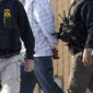 **FILE** Immigration and Customs Enforcement (ICE) agents take a suspect into custody on March 30, 2012, as part of a nationwide immigration sweep in Chula Vista, Calif. (Associated Press)