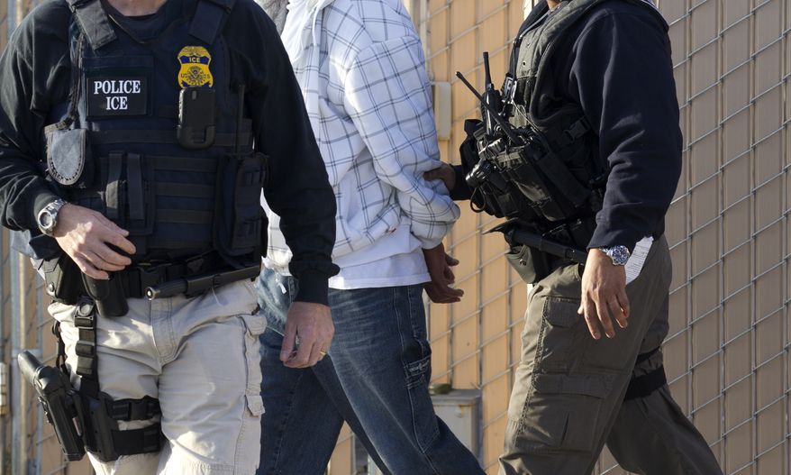 **FILE** Immigration and Customs Enforcement (ICE) agents take a suspect into custody on March 30, 2012, as part of a nationwide immigration sweep in Chula Vista, Calif. (Associated Press)