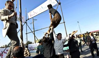 **FILE** In this May 8, 2013, photo released by the Iranian Mehr News Agency, men hold a man hanged in public, to prevent his execution, after he was pardoned by the family of the policeman he was convicted of killing, in Mashhad, northeastern Iran. Under Sharia law, a victim&#39;s family has the option to forgive the criminal rather than allowing the perpetrator to be executed. (Associated Press)
