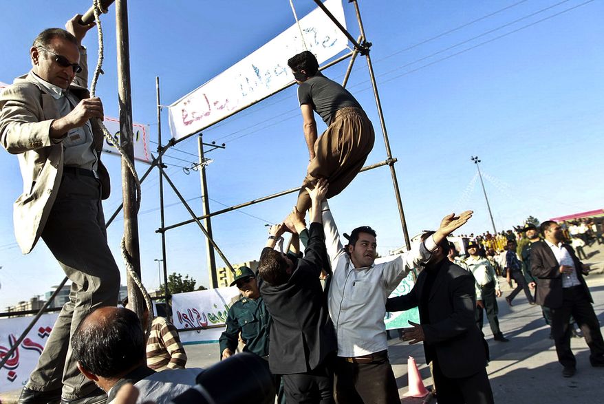**FILE** In this May 8, 2013, photo released by the Iranian Mehr News Agency, men hold a man hanged in public, to prevent his execution, after he was pardoned by the family of the policeman he was convicted of killing, in Mashhad, northeastern Iran. Under Sharia law, a victim's family has the option to forgive the criminal rather than allowing the perpetrator to be executed. (Associated Press)