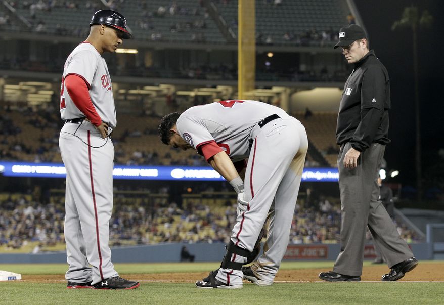 Nationals catcher Wilson Ramos tries to stretch after feeling his left hamstring tighten up again on Wednesday night. (Associated Press photo)