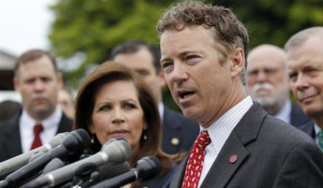Rep. Michele Bachmann, R-Minn., chairwoman of the Tea Party Caucus, listens at left as while Sen. Rand Paul, R-Ky., speaks during a news conference with Tea Party leaders about the IRS targeting Tea Party groups, Thursday, May 16, 2013, on Capitol Hill in Washington. (Associated Press)