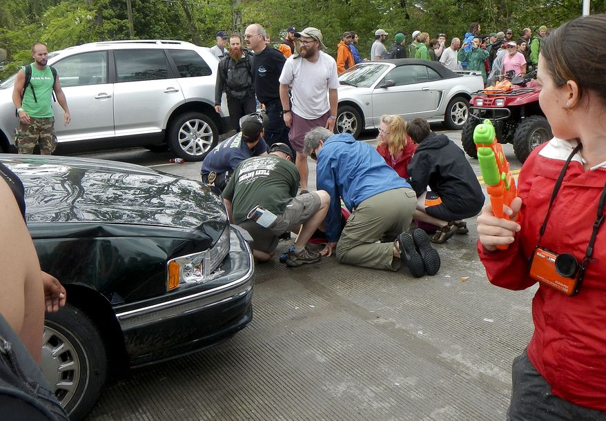 First responders attend to a victim who was hit by a car during the Hikers Parade at the Trail Days festival in Damascus, Va., on Saturday, May 18, 2013. (AP Photo/Republican-American, Bill O'Brien)