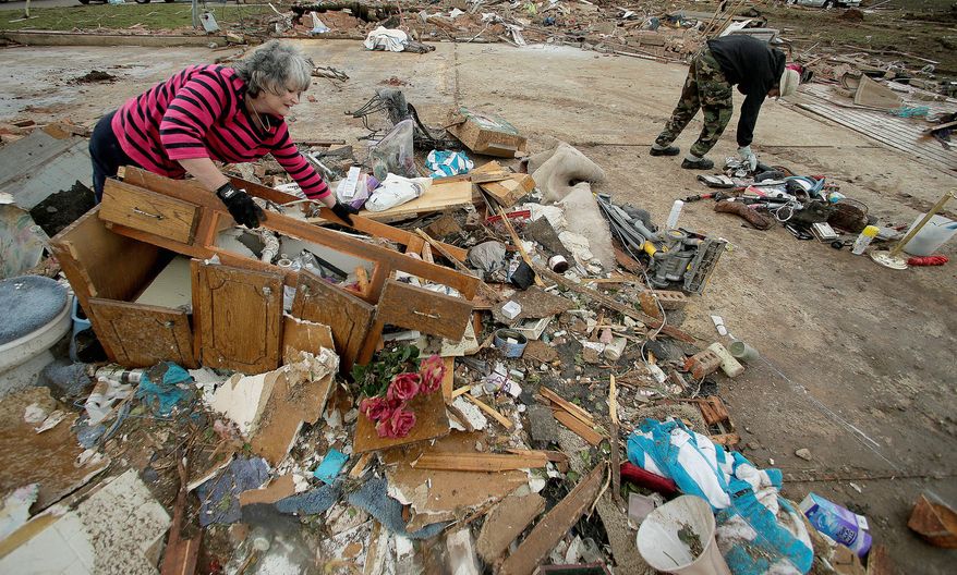 What's Left: Lea Bessinger and her son Josh Bessinger sort through the rubble of Ms. Bessinger's tornado-ravaged home Tuesday.