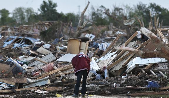 A local resident allowed looks through the rubble of a destroyed home, one day after a tornado moved through Moore, Okla., Tuesday, May 21, 2013. (AP Photo/Brennan Linsley)