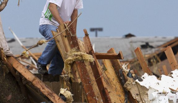 A man searches a damaged home near SW 4th Street and Telephone Road after a tornado moved through Moore, Okla., on Monday, May 20, 2013. (AP Photo/Alonzo Adams)