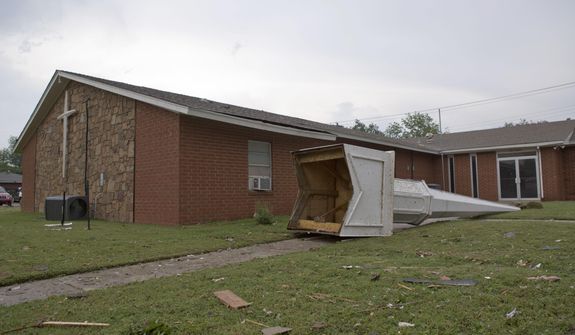 The steeple of a church at South Janeway Avenue and SW 4th Street lays across the lawn after a tornado moved through Moore, Okla., on Monday, May 20, 2013. (AP Photo/Alonzo Adams)