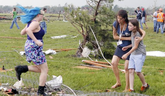 A parent rushes to embrace her child as a teacher escorts her away from Briarwood Elementary school after a tornado destroyed the school in south Oklahoma City, Okla,, Monday, May 20, 2013, near SW 149th and Hudson. (AP Photo/ The Oklahoman, Paul Hellstern)