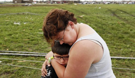 Rebekah Stuck hugs her son, Aiden, 7, after she found him in front of the destroyed Briarwood Elementary School after a tornado struck south Oklahoma City and Moore, Okla., on Monday, May 20, 2013. Aiden was inside the school when it was hit. (AP Photo/The Oklahoman, Nate Billings)