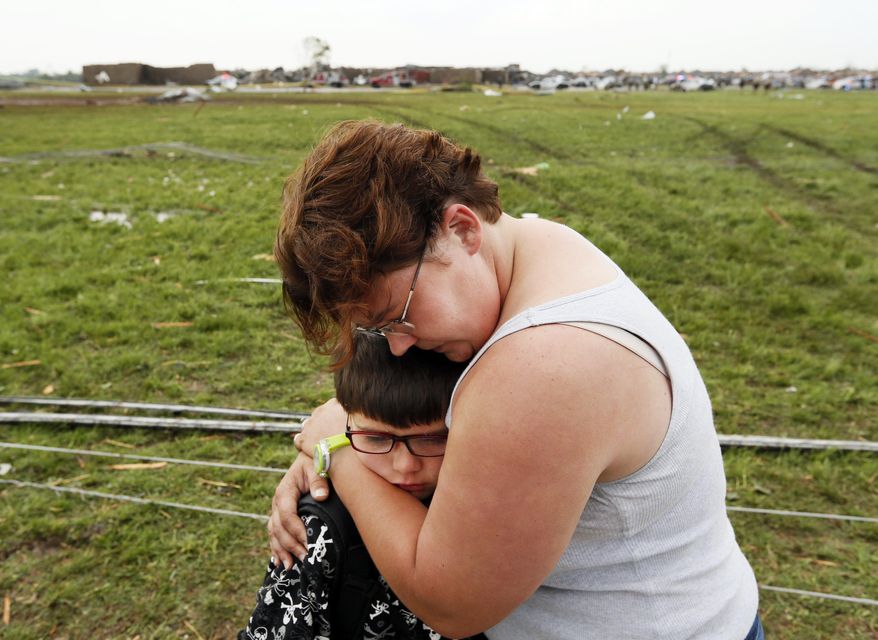 Rebekah Stuck hugs her son, Aiden, 7, after she found him in front of the destroyed Briarwood Elementary School after a tornado struck south Oklahoma City and Moore, Okla., on Monday, May 20, 2013. Aiden was inside the school when it was hit. (AP Photo/The Oklahoman, Nate Billings)