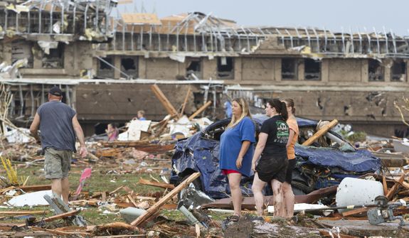 People go through the debris near Telephone Road and SW 4th Street after a tornado moves through Moore, Okla., on Monday, May 20, 2013. (AP Photo/Alonzo Adams)