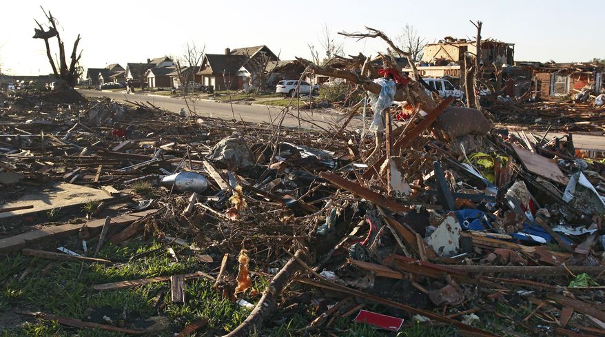 The wreckage of a row of completely leveled homes sits across from a row of partially destroyed houses on Wednesday, May 22, 2013, two days after a tornado moved through Moore, Okla. (AP Photo/Brennan Linsley)