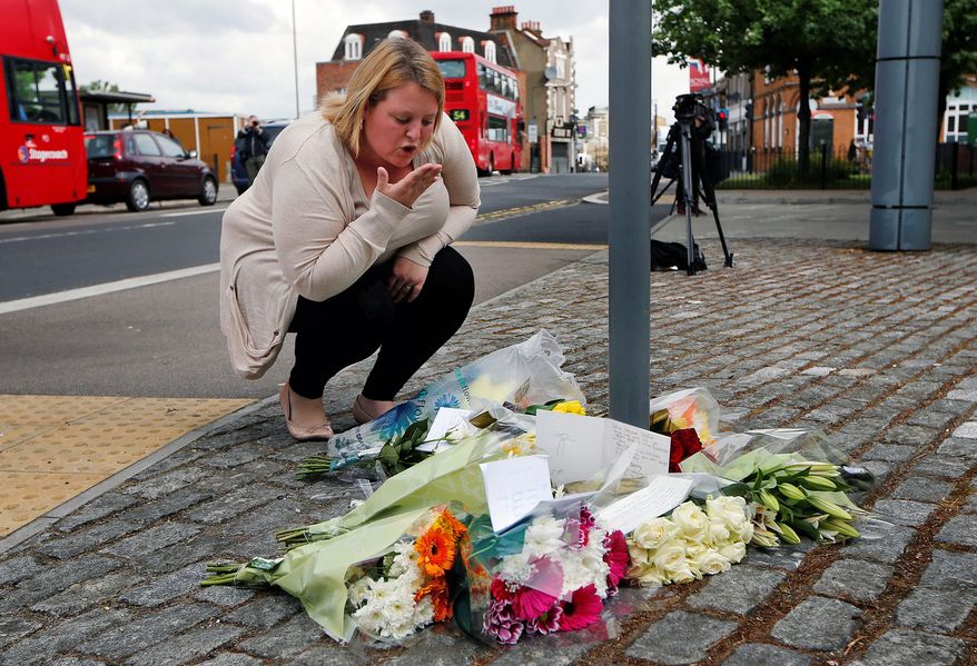 ** FILE ** A woman blows a kiss as she lays a floral tribute in memory of the victim outside the Royal Artillery Barracks near the scene of a terror attack in Woolwich in southeast London on Thursday, May 23, 2013. A member of the armed forces was attacked and killed by two men on Wednesday. (AP Photo/Sang Tan)