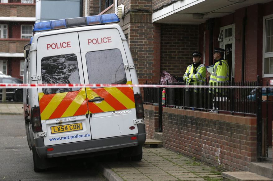 Police officers guard a flat as it is being searched at Greenwich in southeast London on May 23, 2013. A member of the armed forces was attacked and killed by two men on Wednesday at nearby Woolwich. (Associated Press)
