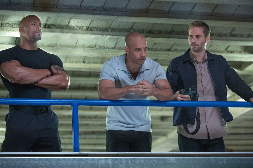 Dwayne "The Rock" Johnson, left, Vin Diesel, center, and Paul Walker in a scene from "Fast & Furious 6." (AP Photo/Universal Pictures, Giles Keyte)