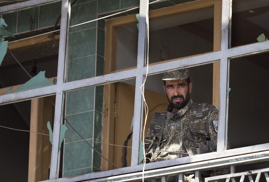 ** FILE ** An Afghan Army soldier peers through a destroyed shop window at the scene where a suicide car bomber attacked a NATO convoy in Kabul, Afghanistan, Thursday, May 16, 2013. A Muslim militant group, Hizb-e-Islami, claimed responsibility for the early morning attack, killing many in the explosion and wounding tens, police and hospital officials said. (AP Photo/Anja Niedringhaus)