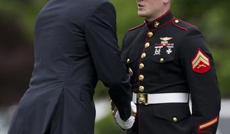 President Obama shakes hands with the Marine at the base of the steps of Marine One on the South Lawn of the White House on May 24, 2013. Obama forgot to salute the Marine as he boarded so he came back out to shake hands with the Marine. The president is traveling to Annapolis to deliver the commencement address at the United States Naval Academy. (Associated Press)