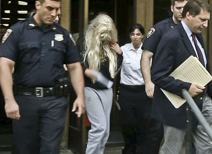 ** FILE ** Amanda Bynes (center), wearing sweats and a blonde wig, is escorted after a Manhattan criminal court appearance on May 24, 2013. (Associated Press/APTN)