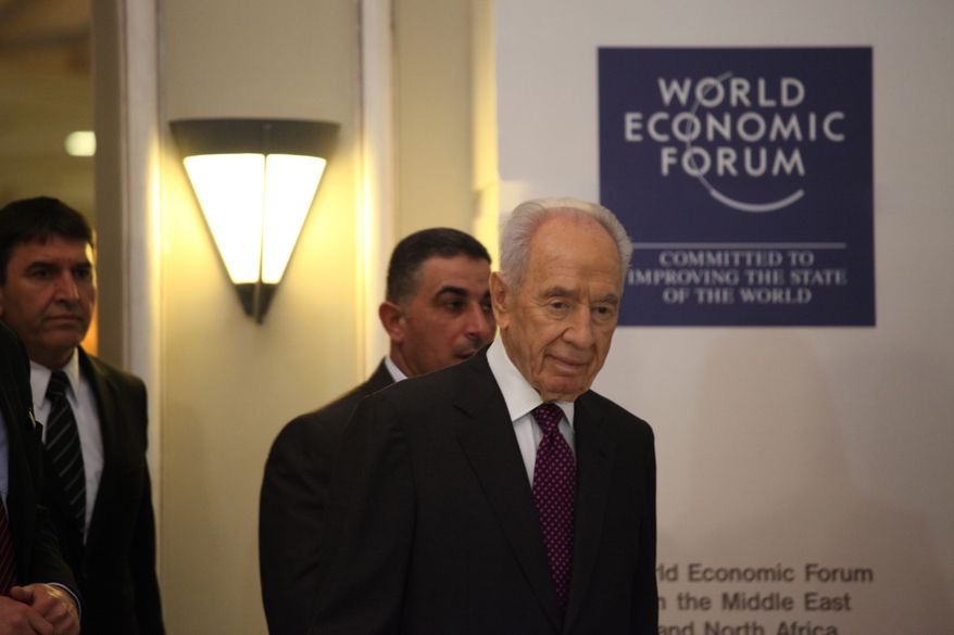 Israeli President Shimon Peres (right) arrives to give a brief statement at the World Economic Forum in Southern Shuneh, Jordan, on Sunday, May 26, 2013. Mr. Peres says that it is possible for Israelis and Palestinians to overcome differences and skepticism over peacemaking and that it is time to restart serious negotiations and conclude a peace treaty that long has dogged the two warring sides. (AP Photo/Mohammad Hannon)