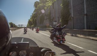 Washington Times Reporter, Meredith Somers, holds her arms out as she is rides down interstate 66, during the annual Ride of the Patriots, in support of Rolling Thunder, in Fairfax, VA., Sunday, May 26, 2013.  (Andrew S Geraci/The Washington Times)