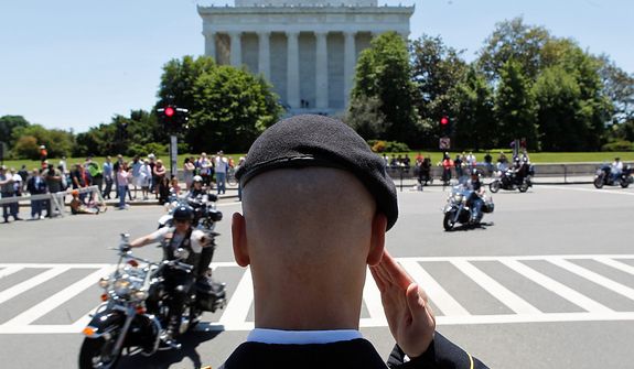 Motorcycles drive past the Lincoln Memorial as Colin Morris, of the US Army, salutes during the annual Rolling Thunder &quot;Ride for Freedom&quot; parade ahead of Memorial Day in Washington, Sunday, May 26, 2013. (AP Photo/Molly Riley)  