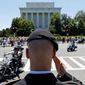 Motorcycles drive past the Lincoln Memorial as Colin Morris, of the US Army, salutes during the annual Rolling Thunder &quot;Ride for Freedom&quot; parade ahead of Memorial Day in Washington, Sunday, May 26, 2013. (AP Photo/Molly Riley)  