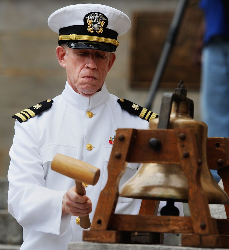 U.S. Navy veteran Paul Webb strikes the bell throughout the Memorial Day service, in Lynchburg, VA., Monday, May 27, 2013. (AP Photo/News & Daily Advance, Sam O'Keefe\)