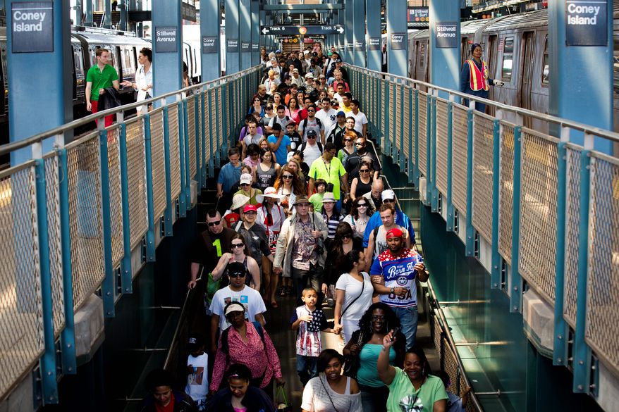 Dozens of beach-goers spill down an exit ramp on Memorial Day at Coney Island, Monday, May 27, 2013, in New York. Despite cool weather and cold water, thousands of visitors took to the sand and the boardwalk. (AP Photo/John Minchillo)