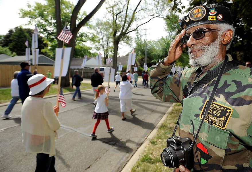 Staff Sgt. Edgar A. Feagines,of Ferndale, who was in the Air Force from 1959-70 and served in Vietnam, salutes Michigan's Fallen Foot Float in the Ferndale Memorial Day parade in Ferndale, Mich., on Monday , May 27, 2013. In a special tribute to the men and women who gave their lives serving Michigan's military units in Iraq and Afghanistan conflicts, a local committee of volunteers is honoring Michigan's fallen heroes by participating in the Fallen Foot Float. (AP Photo//The Detroit News, David Coates)